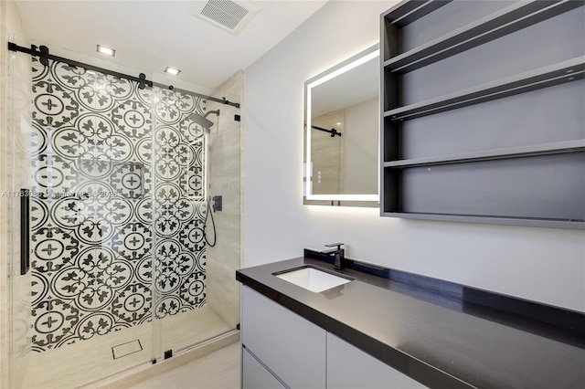 full bathroom featuring visible vents, a stall shower, and vanity