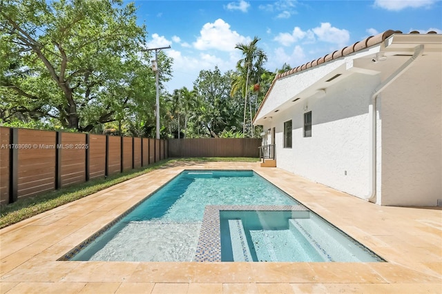 view of swimming pool featuring a patio, a pool with connected hot tub, and a fenced backyard