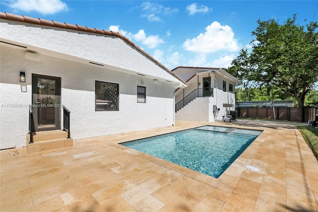 view of swimming pool with stairway, fence, a fenced in pool, central air condition unit, and a patio area