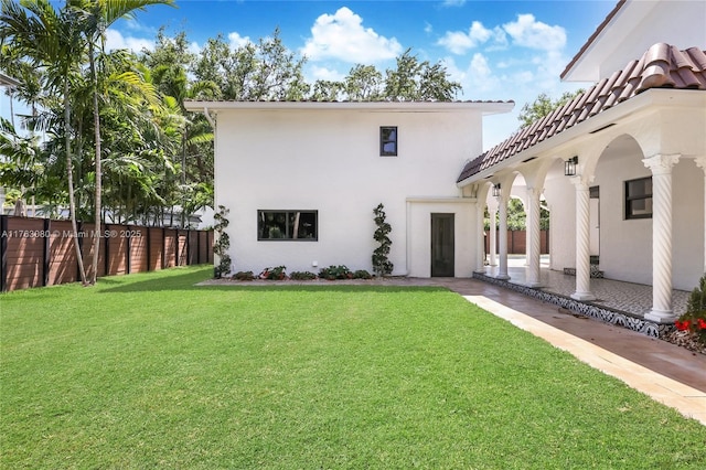 back of property featuring a patio area, stucco siding, a yard, and fence