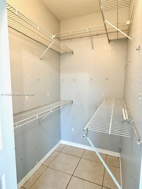 walk in closet with tile patterned floors