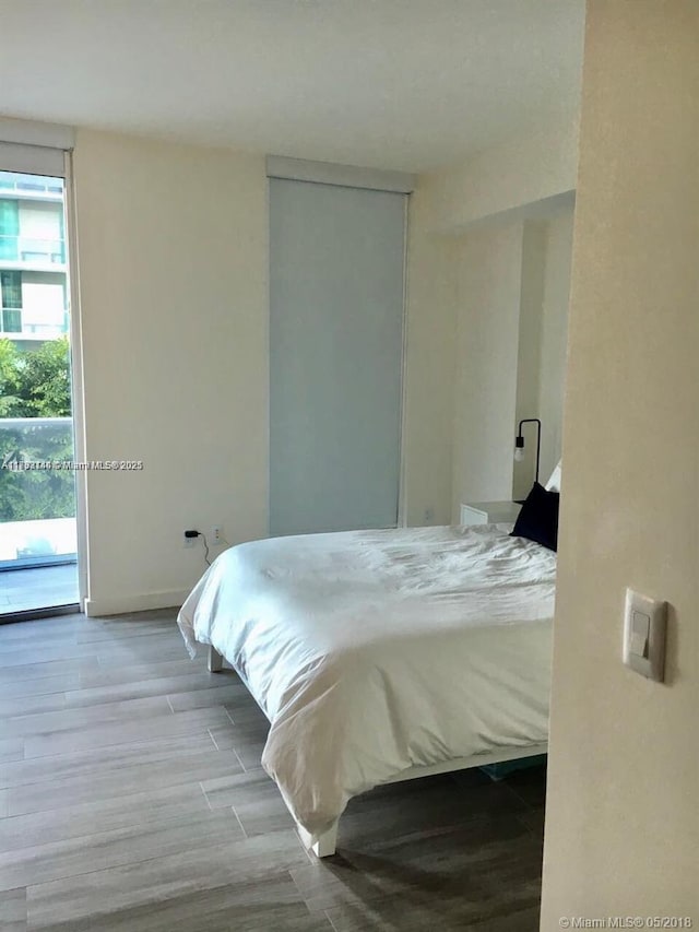 bedroom featuring access to outside and wood finished floors