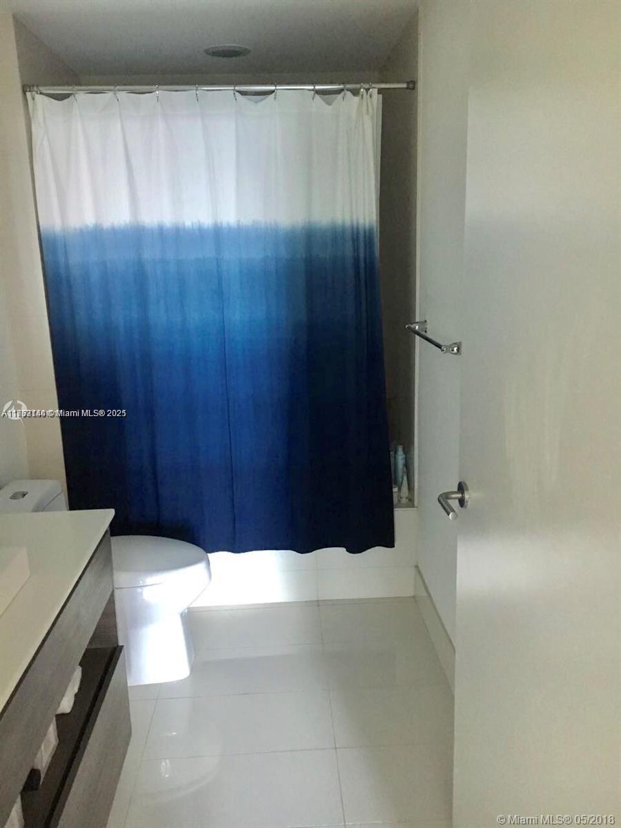 bathroom with tile patterned flooring, toilet, and vanity