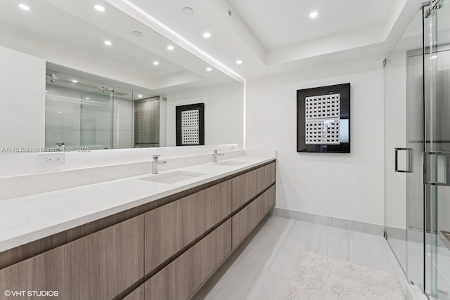 bathroom featuring a shower stall, a raised ceiling, and a sink