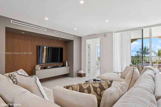 living area featuring floor to ceiling windows, recessed lighting, and visible vents