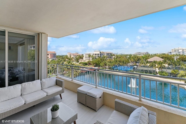 balcony with an outdoor living space and a water view