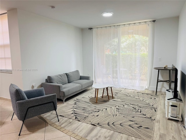 living area with baseboards and wood finished floors