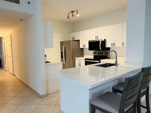 19555 E Country Club Dr Unit 8108, Aventura, FL 33180 - kitchen featuring a peninsula, stainless steel appliances, a sink, a breakfast bar area, and light tile patterned floors