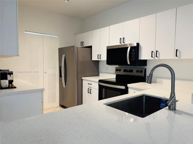 19555 E Country Club Dr Unit 8108, Aventura, FL 33180 - kitchen with stainless steel appliances, white cabinetry, a sink, light stone counters, and light tile patterned floors
