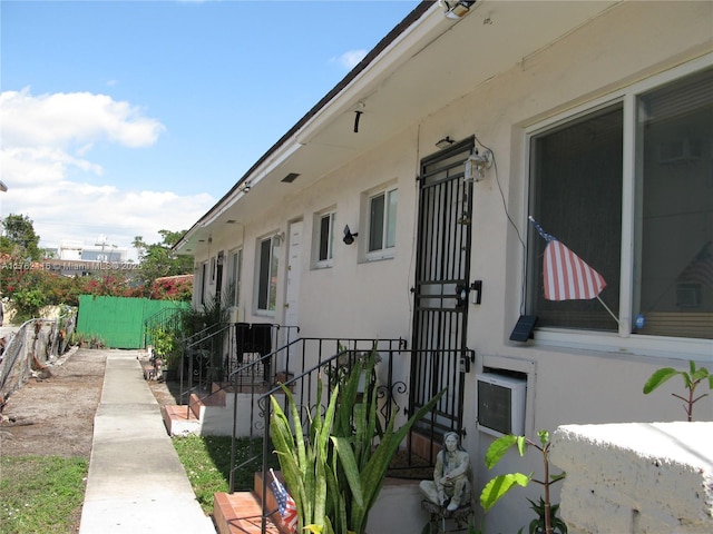 view of side of property featuring stucco siding and fence