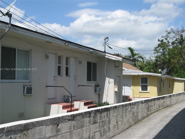 exterior space featuring stucco siding and fence