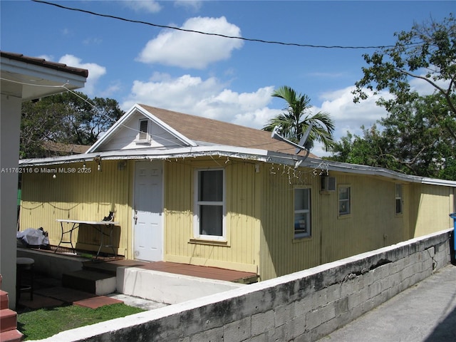 view of side of property with roof with shingles