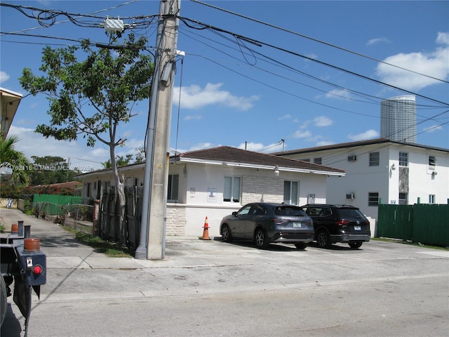 exterior space featuring fence, stone siding, and stucco siding