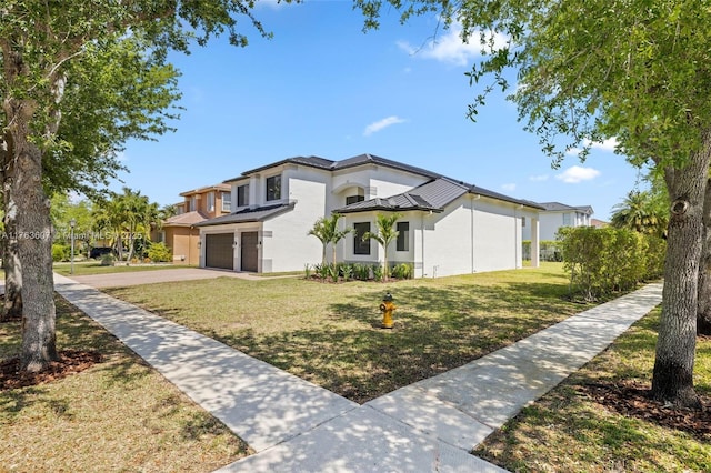 view of front of home with a garage, concrete driveway, a front lawn, and stucco siding