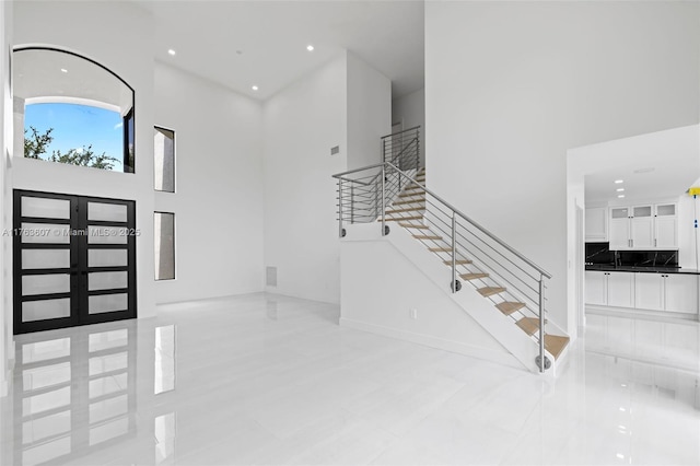 entryway with recessed lighting, stairway, and a high ceiling