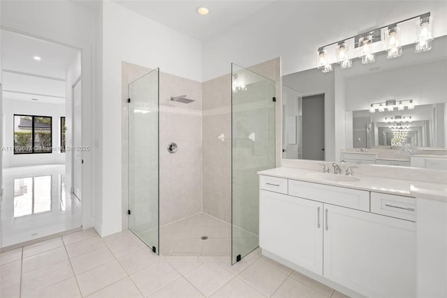 bathroom featuring tile patterned floors, tiled shower, and vanity