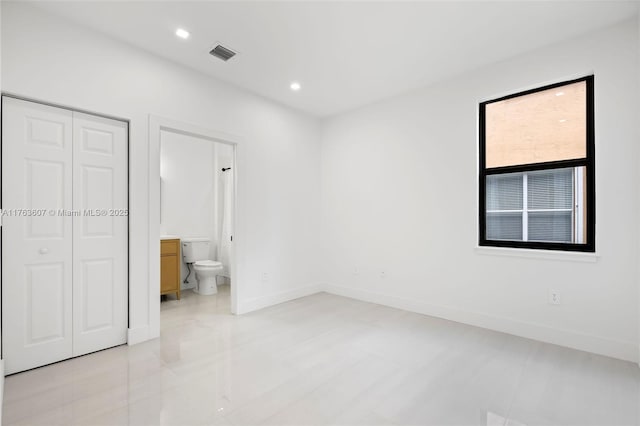 unfurnished bedroom with visible vents, baseboards, recessed lighting, a closet, and ensuite bath