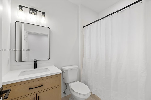 bathroom featuring toilet, vanity, and a shower with curtain