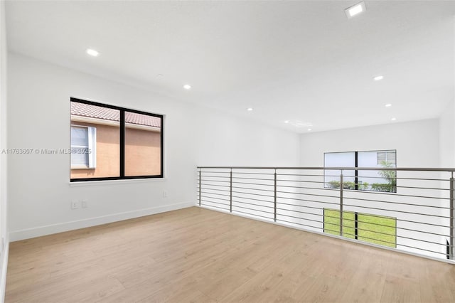 empty room featuring recessed lighting, wood finished floors, and baseboards