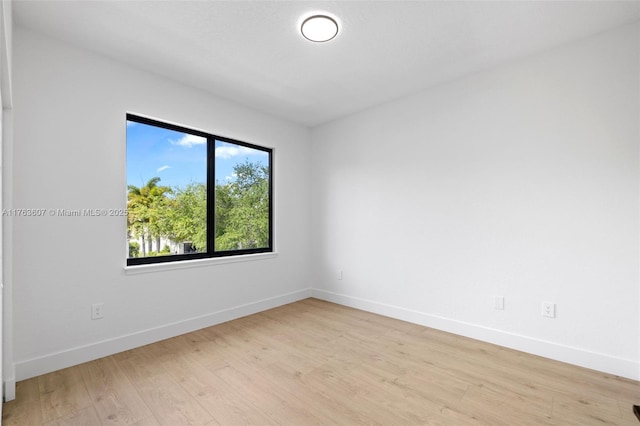 unfurnished room with baseboards and light wood-style floors