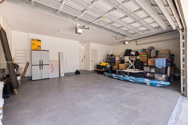 garage with freestanding refrigerator and a garage door opener