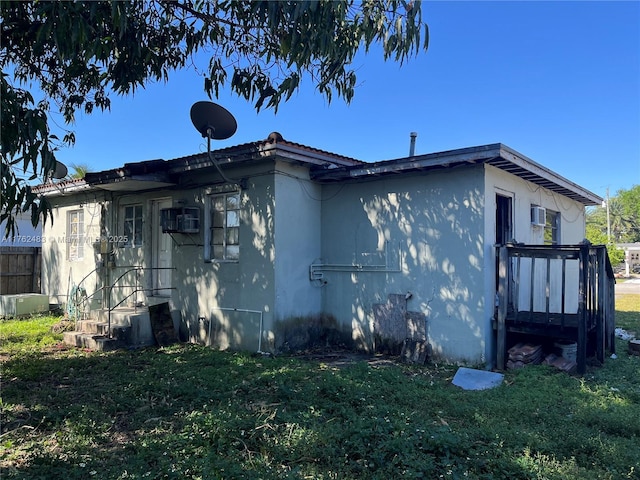 view of side of property with a tiled roof, a yard, fence, and stucco siding