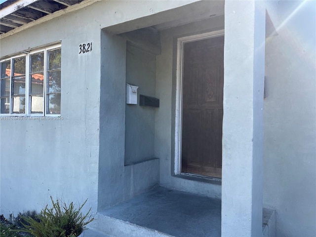 doorway to property featuring stucco siding