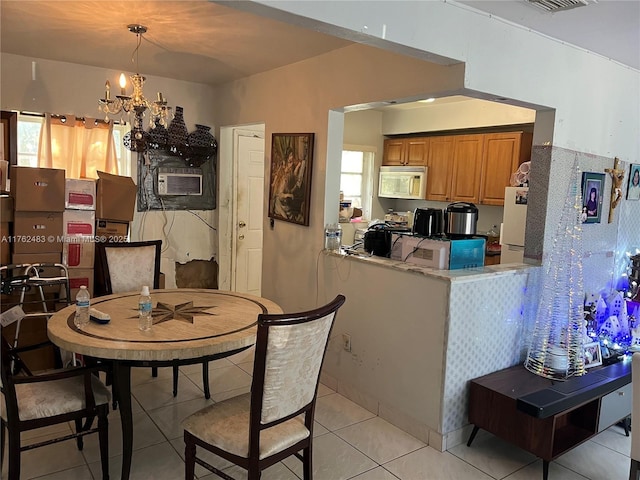 dining area featuring light tile patterned floors and a chandelier