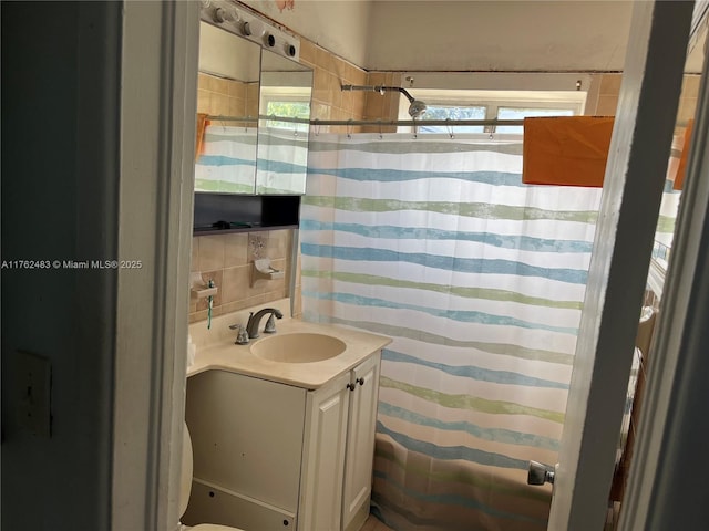 full bathroom with a shower with shower curtain, plenty of natural light, tasteful backsplash, and vanity