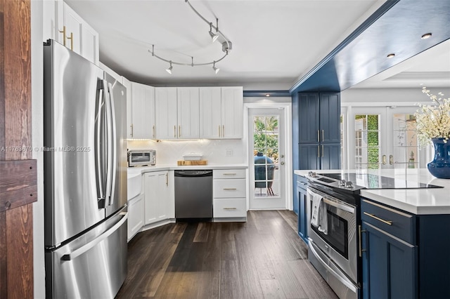 2395 SE 6th St, Pompano Beach, FL 33062 - kitchen with appliances with stainless steel finishes, blue cabinets, light countertops, and a wealth of natural light