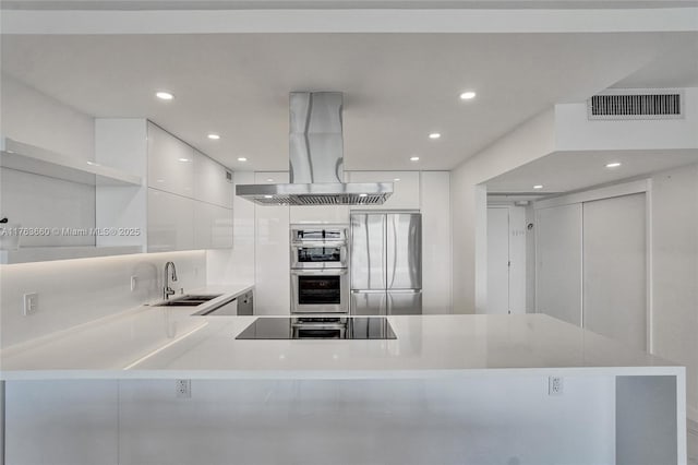 kitchen featuring visible vents, island exhaust hood, white cabinets, appliances with stainless steel finishes, and modern cabinets