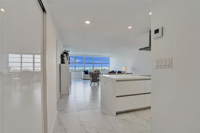 hall with recessed lighting and marble finish floor