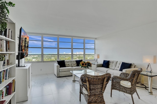 living room with plenty of natural light, marble finish floor, and baseboards