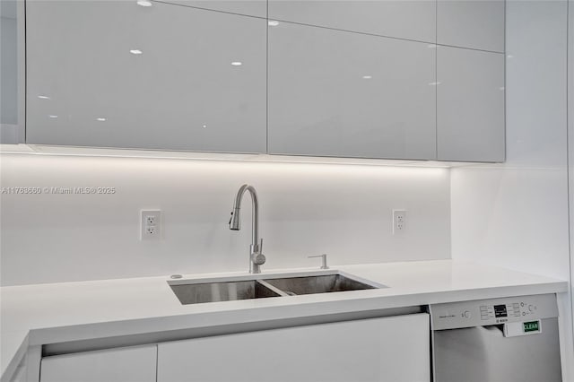 kitchen featuring a sink, dishwasher, light countertops, white cabinetry, and modern cabinets