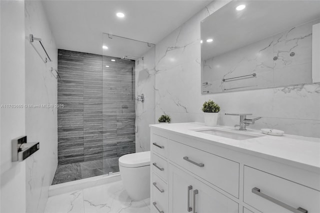 bathroom with vanity, a shower stall, tile walls, toilet, and marble finish floor