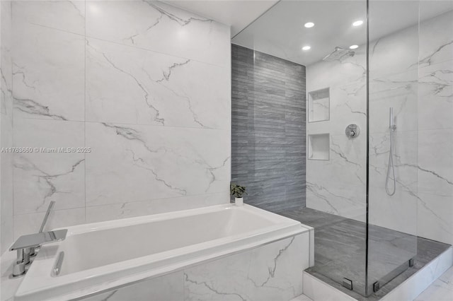 bathroom featuring a bath, recessed lighting, a marble finish shower, and tile walls