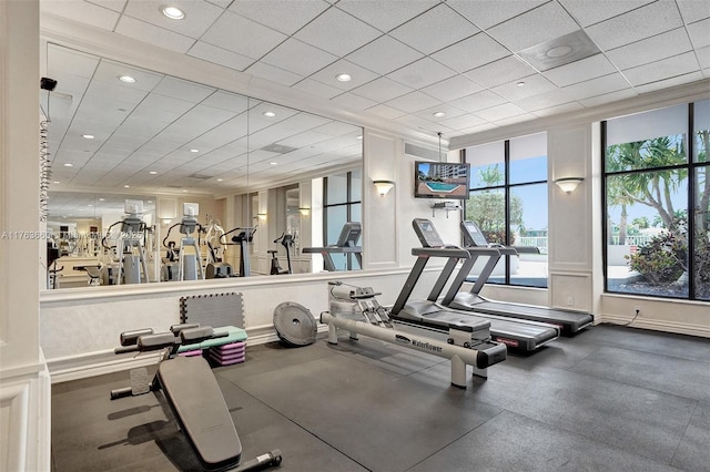 exercise room featuring recessed lighting, a paneled ceiling, and baseboards