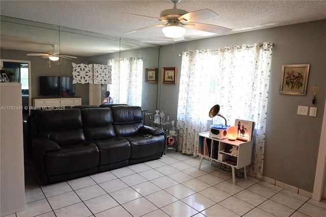 living area featuring light tile patterned floors, a textured ceiling, and ceiling fan