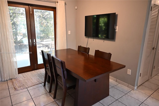 dining space with light tile patterned flooring, french doors, and baseboards