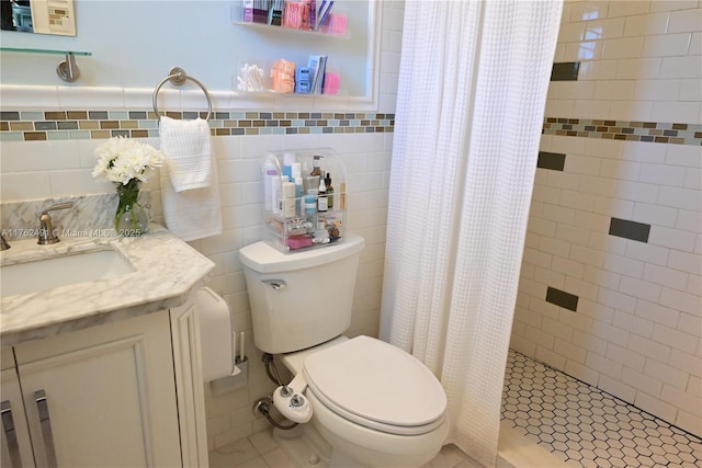 bathroom with vanity, toilet, tile walls, and a shower stall