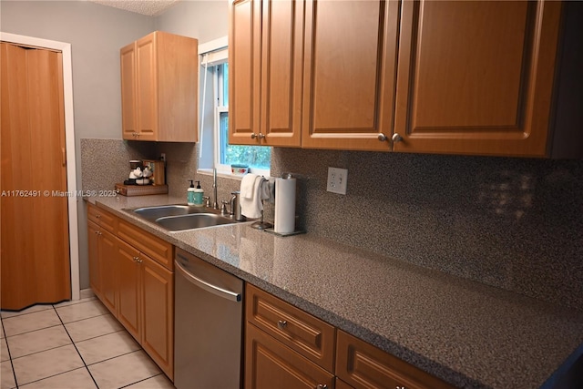 kitchen with light tile patterned flooring, a sink, backsplash, and stainless steel dishwasher