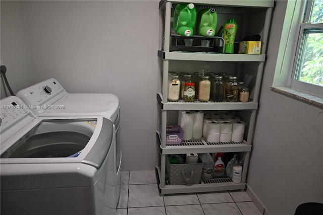 clothes washing area with light tile patterned floors, washing machine and dryer, and laundry area