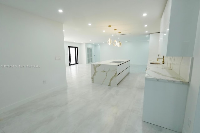 kitchen featuring open floor plan, recessed lighting, a large island, white cabinets, and modern cabinets