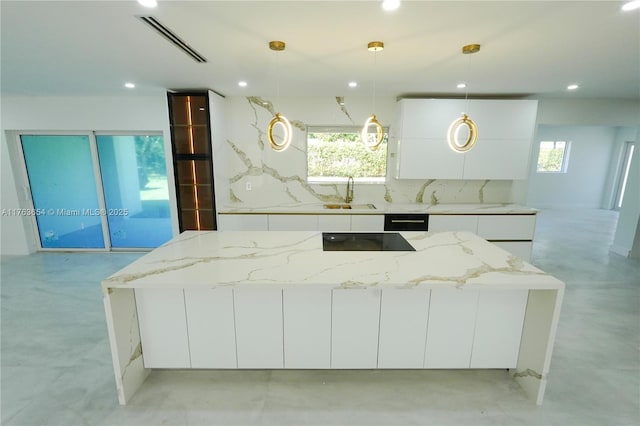 kitchen featuring white cabinets, modern cabinets, visible vents, and a sink