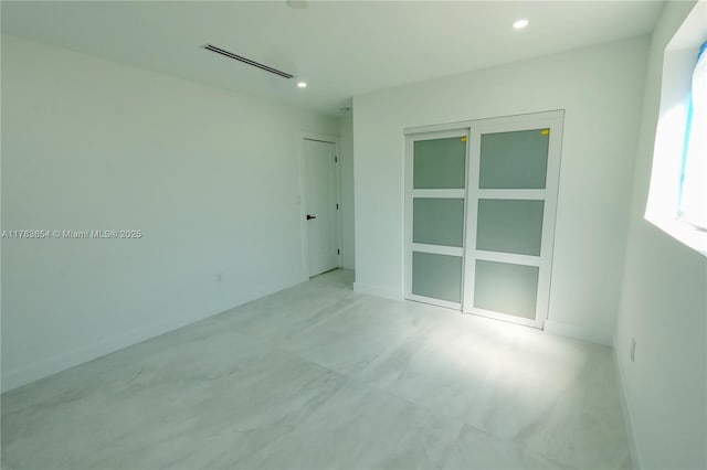 empty room featuring recessed lighting, visible vents, and baseboards