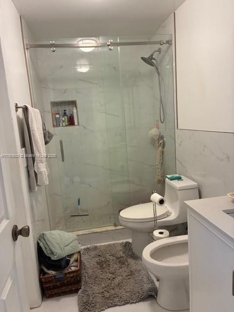 full bathroom with a marble finish shower, toilet, tile walls, and vanity