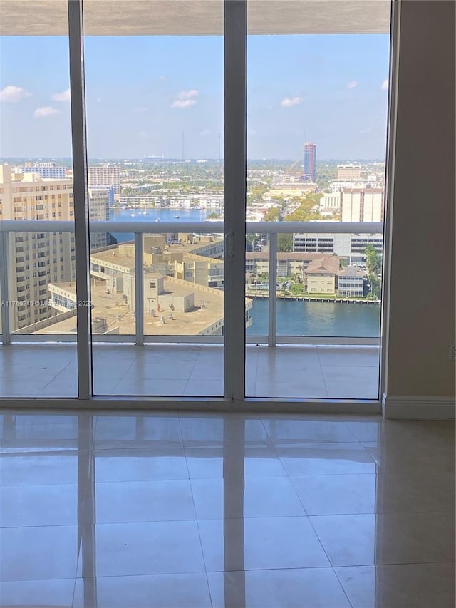 empty room featuring a view of city, plenty of natural light, and a water view