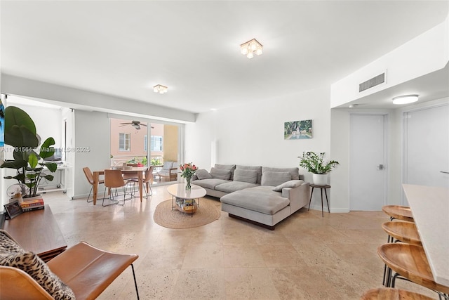 living area featuring visible vents, baseboards, and a ceiling fan