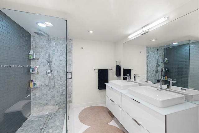 full bathroom featuring a shower stall, double vanity, and a sink