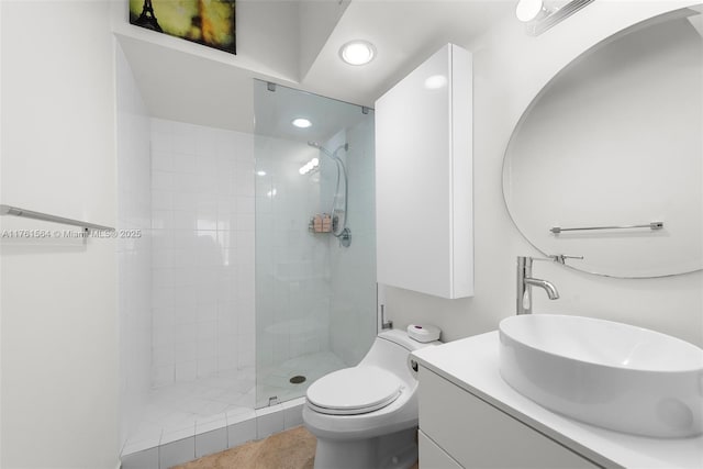 full bathroom featuring a tile shower, recessed lighting, toilet, and vanity